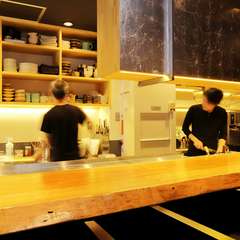 オープンキッチンから見せる清潔感と、心地よい活気の店内
