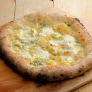 自慢の「石窯ピザ」。4種類のチーズが織りなす「パンチの効いたハーモニー」がたまりません。好みでハチミツをかけてもGood。薪を使い高温で焼き上げているので、外はカリッとしていて、中はモッチリ食感です。