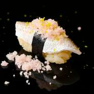 瀬戸内を象徴する海の幸であるチダイ（小鯛）を、江戸前鮨の技法で仕込み、自家製おぼろ等を添えたオンリーワンの一貫。口のなかでストーリーが広がるような、奥深い味わいを楽しめる【吉鮨】の看板鮨です。