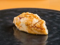 優しく煮た穴子は、とても柔らかくふわふわの仕上がり。提供直前に炙り香ばしさもプラス。口に入れた瞬間、穴子がとろけるように一気に広がり、煮汁を詰めた甘だれとシャリが三位一体となり“口福”をもたらします。