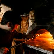 2003年創業以来、石窯でピザを焼き続けるオーナーシェフ・平山氏。毎朝手練りする生地は天候に合わせて配合などを調整。手間暇を惜しまないことで「変わらぬおいしさ」が実現します。