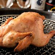 丸鶏はじっくり焼くのがベスト！程よいサイズの雛鳥を丸ごとローストし、じっくり焼き上げた後、燻製して完成。桜とローズウッドの香りが食欲をくすぐります。シェアスタイルにもおすすめ。（※平日は要予約）
