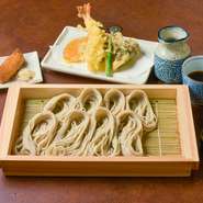そば粉と布のりだけでつくるへぎそばは、のど越しが良く独特の歯応え。「へぎ」と呼ばれる器に小分けにして並べるのも特徴で、ワサビではなく和辛子をつけていただきます。海老と季節野菜の天麩羅、いなり寿司付き。