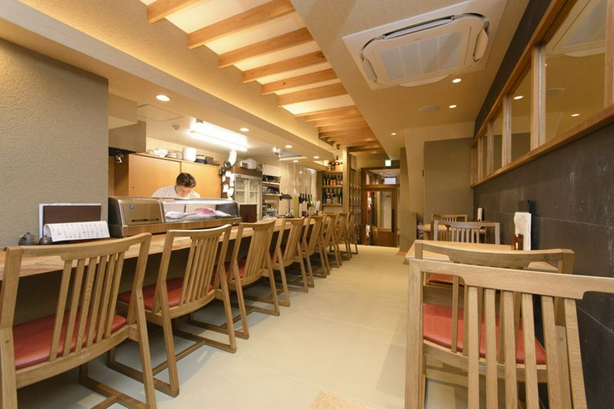 ゆっくりと料理と酒を味わえる広い1枚板のカウンター席