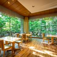 全面ガラス張りの向こうに日本庭園が広がるテーブル席。開放感抜群で、昼は豊かな緑が目に映え、夜は雰囲気たっぷりのくつろぎの空間が広がります。