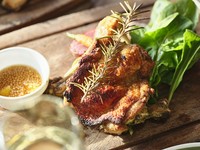 ハーブを効かせたモモ肉にローストポテトを添えて