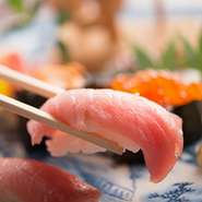 店主が毎朝市場に出向き、旬の魚介を厳選。まずは『江戸前にぎり』や『刺身』で、素材本来の旨みをダイレクトに味わうのがおすすめです。『骨蒸し』や『焼もの』など、熟練の技が利いた割烹品質を堪能できます。