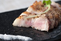 厚切りのロース肉に黒コショウを振って炙り焼きにしています。火加減にこだわりあえてレアで仕上げております。山葵と一緒に楽しんで下さい。