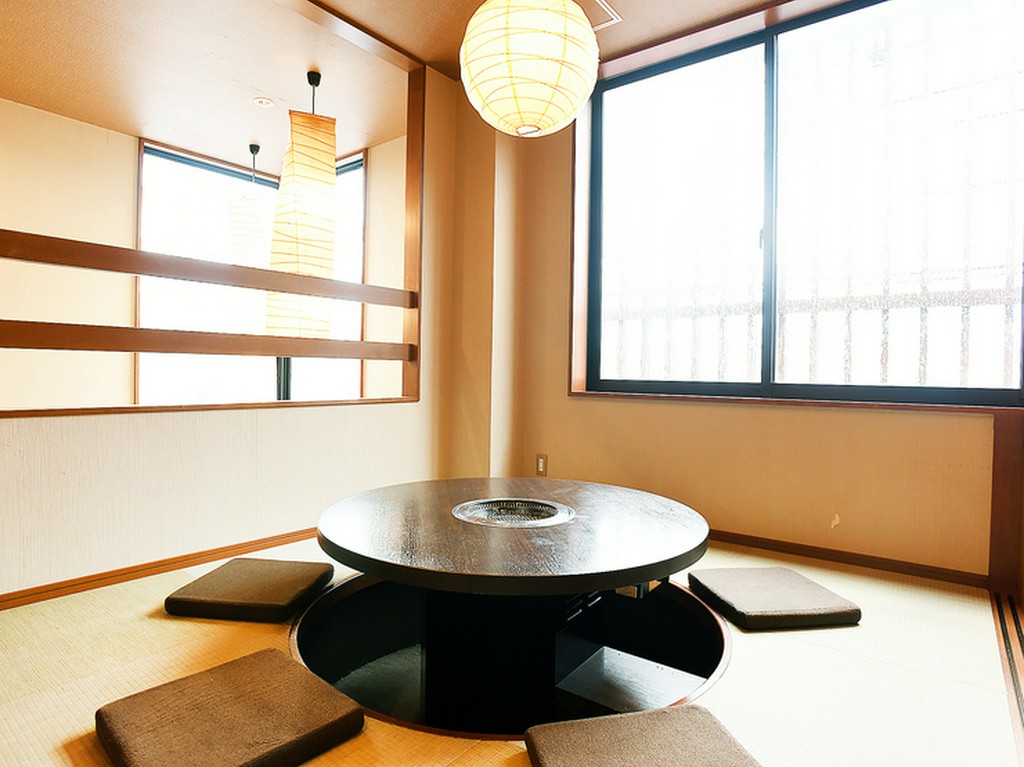 掘りごたつのお座敷席で、焼肉を囲んで一家団らん