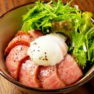 厳選して仕入れした黒毛和牛A5ランクのもも肉を使った、贅沢な丼。自家製の特製ニンニクだれを使用。やみつきになるおいしさで、スタミナ満点メニューです。スープや焼き野菜の付いたコース。