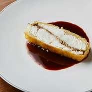 丁寧な神経締めを施したクリアな味わいの鱸にキノコのバターソテーを挟み、細かく刻んだジャガ芋で包んで焼き上げた逸品。重層的な素材の香りとデーツビネガーの酸味のあるソースで味の広がりを楽しめます。