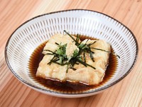 沖縄で豆腐として食されてきたジーマーミー（落花生）豆腐。店では濃厚に仕上げ、一度揚げることで外はサクッと中はもっちり食感に。出汁のきいたつゆでいただきます。