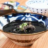 糸満海人の定番料理の一つ「イカ墨汁」。店では、濃厚なイカ墨に野菜の旨味と甘みを加え、カツオ・昆布・いりこから丁寧にとった出汁をベースに作っています。豊かな味わいと出汁の良い香りも楽しめるイカ墨汁です。