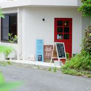 白い建物に真っ赤な扉の小さなお店は、静かな住宅街の丘のふもとにあります。お店を示すのは扉横に立てかけられた看板のみ。すんなりとはたどり着けず、初めて訪れるゲストは迷うことが多いそうです。