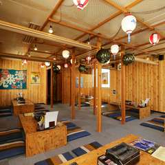 漁具や大漁旗が飾られた、活気に満ちた居酒屋空間