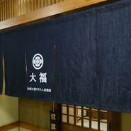 日本料理店でもカジュアルな、入りやすい店という印象にしたいということで、デニム好きな店主が「京都デニム」でつくってもらったというオリジナルののれん。文字の配置にもこだわった逸品です。