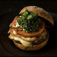 仔羊肉150gをチョップしたジューシーなパティにフェタ＆モントレージャック2種類のチーズとタルタル＆ハリッサ2種類のソース、タブーリと野菜を特製のバンズに挟んだ食べ応え十分の当店のスペシャル・バーガー。