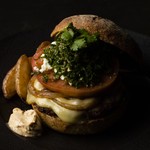 仔羊肉100gをチョップしたジューシーなパティにフェタ＆モントレージャック2種類のチーズとタルタル＆ハリッサ2種類のソース、タブーリと野菜を特製のバンズに挟んだ【CARVAAN】のスペシャル・バーガー。