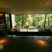 店をぐるっと囲むように設えられた庭には草木が生い茂り、大きな窓からはその美しい景色を眺めることができます。外からの目隠しにもなり、隠れ家のような雰囲気を演出。街の喧騒から離れ、優雅な時間を過ごせます。