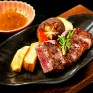 鹿児島牛ロース肉のステーキ。とても柔らかく、箸で食べられるステーキは日本料理のメインとしても好評です。リンゴと玉ねぎたっぷりの特製ステーキたれを添えて、季節の焼き野菜とともに提供されます。