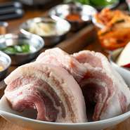 国産豚のバラ肉を、4cmもの厚さにカットした大満足の一品です。サムジャン・ニンニク・レモン・ごま油など好みの薬味味をつけて、サンチュと共に。生肉ならではのジューシーな旨みを堪能できます。
