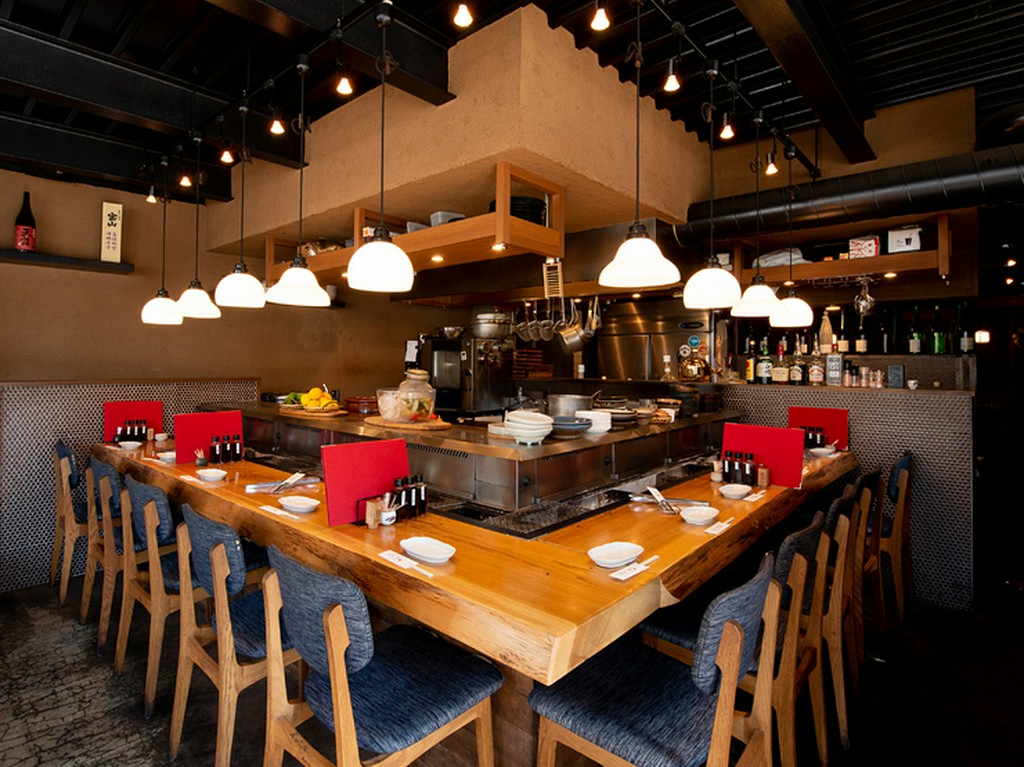 活気のあるオープンキッチンは目の前で料理が見られる特等席