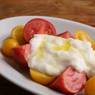 「FARM YARD いしの」の水耕栽培でつくられたトマトは甘みも酸味も皮もしっかりしたおいしいトマト。生クリームと合わせたブッラータチーズに香りの良いオリーブオイルでシンプルに引き出します。