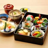 バラエティ豊かな料理と天ぷら、季節のご飯などが付いたランチ限定の弁当。舌でも目でも楽しめる人気メニューです。追加料金でご飯を鰻半丼に変更可能。
注）土・日・祝日は前日までのご予約をお願いいたします。