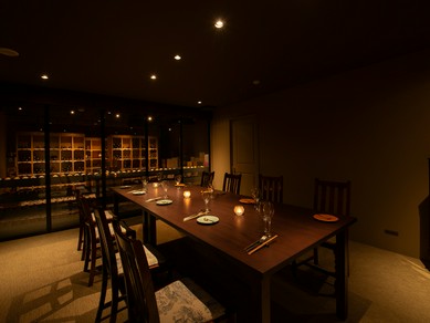 ガラス越しにワインセラーを見渡す、隠れ家のような地下個室