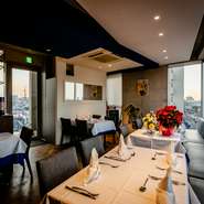 シックで落ち着いた雰囲気の店内は、テーブル配置もゆったりとしたくつろぎ空間です。ブルーの天井はナポリの海をイメージしたといい、テーブルの真っ白いトップクロスの下にも鮮やかなブルーがのぞきます。