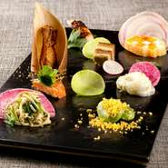 下から上へいただくことでゲストの運気が上がるよう、盛り付けと味付けに工夫を凝らしたメニュー。圧倒的なインパクトを持つ7～8品が並びます。名匠と謳われる田村シェフならではの傑作を堪能して。