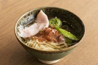粉砕した車海老の頭と鰹節を使い、サイフォンで出汁を取ったスープにカッペリーニを合わせました。トッピングには海老の頭と島とうがらしを煮出してつくったラー油をかけてピリ辛に。