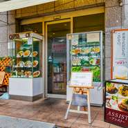 出入口のショーケースには、カラフルな料理がズラリ並んでいます。さらには、ランチやその日のおすすめメニューが書かれている立て看板も…。道行く人たちが、つい足を止めてのぞき込んでしまいます。