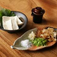 これまでにたくさんの食材を食べ比べしてきた経験を活かし、料理人が選び抜いたこだわりの豆腐を使用しています。塩や鰹節などの薬味が添えられ、お酒との相性も抜群です。