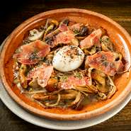 スペイン美食の街・サン・セバスティアンの名店「カンバラ」を元に、厳選したキノコ数種類をジョスパーオーブンで炭火焼きにした上からトリュフバター・半熟トロ卵・スペイン産生ハムをのせて。芳醇な香り漂う一皿。