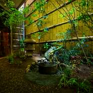カウンター席から見える坪庭は、京都龍安寺の「吾唯足知の蹲踞（くつばい」をイメージしており、手水鉢も龍安寺のものを再現。季節の移ろいを楽しめるように、庭木は年に5回植え替えています。