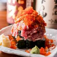 かっぱ巻きの上に、ネギトロ・かに・雲丹・いくら・とびっこなどを豪快に盛り付けた店の名物兼オリジナルメニュー。赤くそびえるその姿から名付けられ、4～5名でシェアできるボリューム感です。