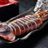 「本日のおすすめ　焼物」より、新鮮なイカを酒と塩で漬け込んで一夜干しにしてから、さらに塩で下味をつけ、炭火で焼き上げます。自家製みそとバター、ゴロ（内蔵）を合わせたタレを絡ませてると、旨みが倍増！