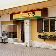 分譲マンションに囲まれた小さなショッピングセンター「新ゆりグリーンプラザ」に佇む店は、石造りで上品なたたずまい。お買い物ついでの食事やテイクアウトに訪れるファミリー層のファンを増やしている。