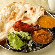 選べるカレー2種にサラダ、タンドリーチキン、シークカバブ、ナンにドリンクと、インドの魅力が全て味わえるお得なランチセットです。カレーは辛さ控えめで、ハーブやスパイスの香りと奥深い旨味が感じられます。