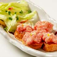 同店自慢の鮪のタタキを、ガーリックバターを塗ったトーストと共に食す看板メニュー。にんにくとバターの香りがたまらず、お酒が進むこと間違いなしのおいしさです。