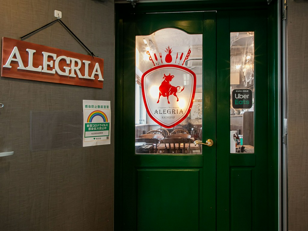 オシャレなグリーンの扉に牛のイラストがオシャレ