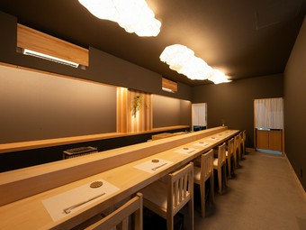 一枚板カウンターと照明が特徴的。無駄を削ぎ落とした上質な空間