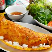 ベトナム料理レストランの定番といえばバインセオ。店のメニューには『海鮮パリパリお好み焼き』の名で登場。イカ、海老にたっぷりのもやしを加え、米粉にターメリックを加えた生地で焼いたもので、食べごたえ満点。