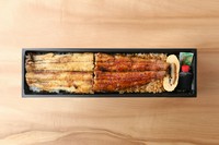 蒲焼きと白焼きを半分ずつ味わうことが出来る新メニューが、今だけお買い求めになれます。
当店で人気のうまきも１つ付いてきます。