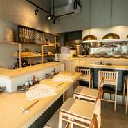 白木のテーブルやイス、亀甲柄タイルを貼ったカウンターに、モダンな照明。無駄な装飾を省き、和洋のインテリアをさりげなく置いた店内は、親しみやすさと品の良さあり。のんびり逸品を楽しめる空間です。
