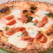 薪窯で本場の伝統の焼き方を守ってつくられるピザ。外はパリッ、なかはふっくらと軽い食感は高温で一気に焼き上げるからこそ。「軽いからいくらでも食べられる」と話題の常連の方に人気のメニューです。