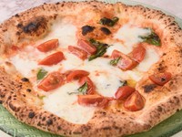 薪窯で本場の伝統の焼き方を守ってつくられるピザ。外はパリッ、なかはふっくらと軽い食感は高温で一気に焼き上げるからこそ。「軽いからいくらでも食べられる」と話題の常連の方に人気のメニューです。
