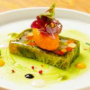 コンソメのジュレで、旬の野菜を彩り良く寄せたテリーヌ。その上には、レッドパプリカを使った、なめらかな口当たりのムースが添えられています。ビジュアルも美しく、目でも楽しめる一品です。