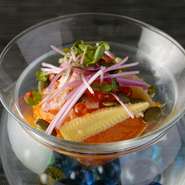 ガラスの器の中には涼しげなジュレを敷き、その上に緑・赤・黄などの彩り豊かにな食材を散らされています。